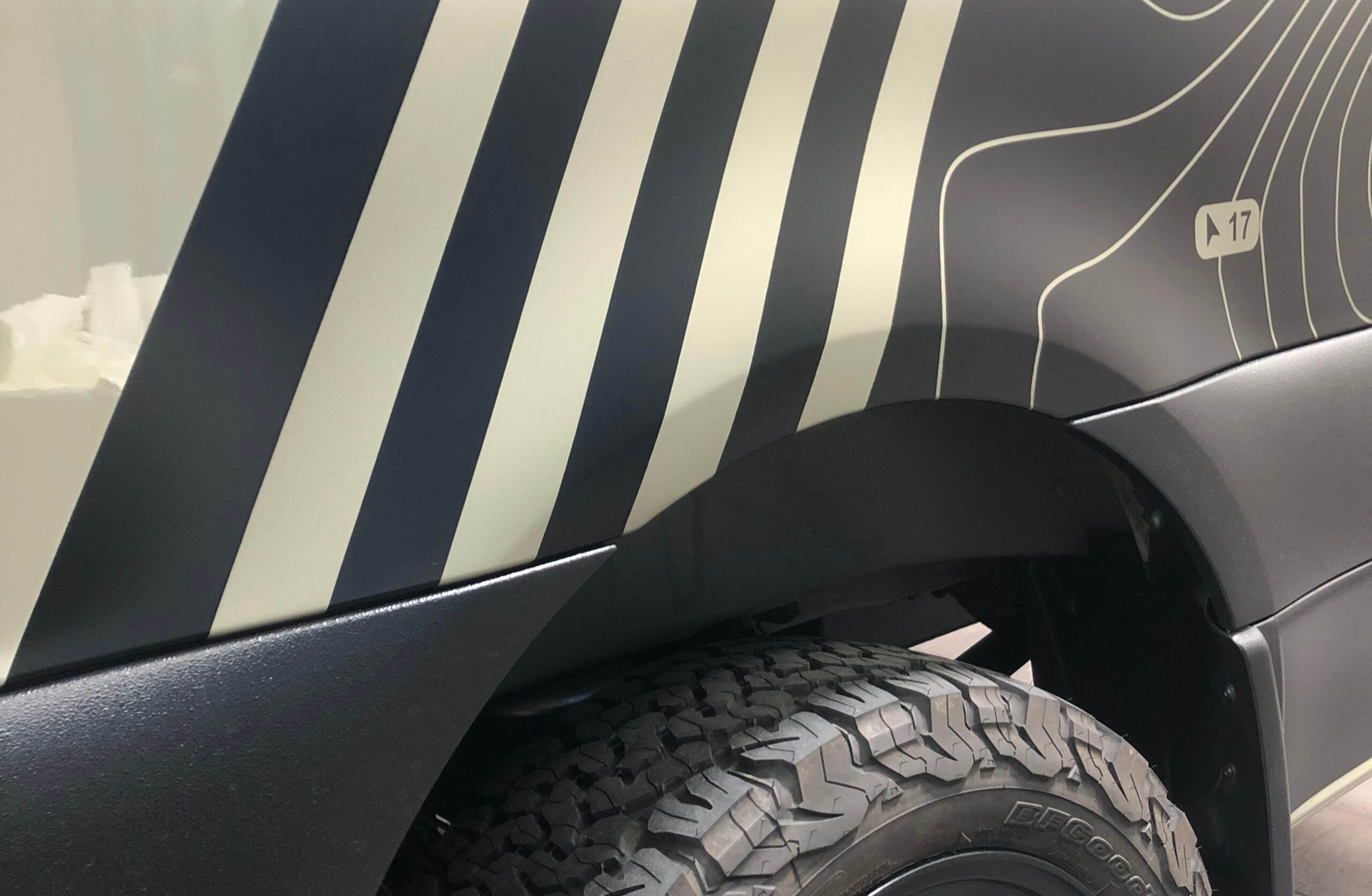 Camper Folierung – präzise Detailarbeit mit grafischem Linienmuster Detailaufnahme einer Camper-Folierung mit Linienmuster im Bereich des hinteren Kotflügels
