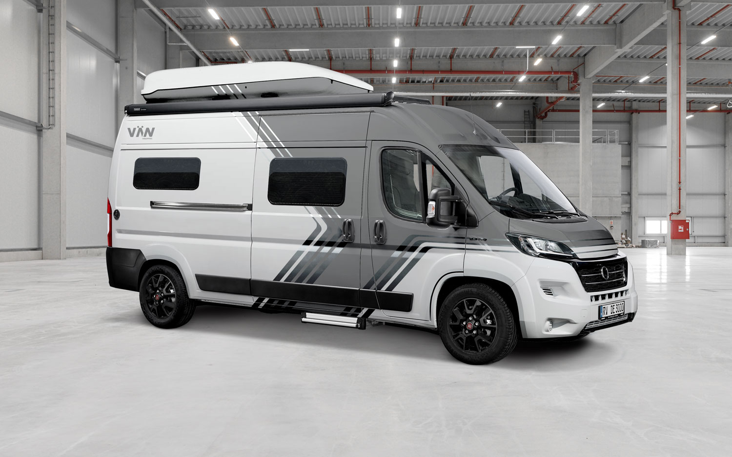 Fiat Ducato Camper – Designfolierung in der Manufaktur Fiat Ducato Camper mit grauer und schwarzer Designfolierung in moderner Produktionshalle