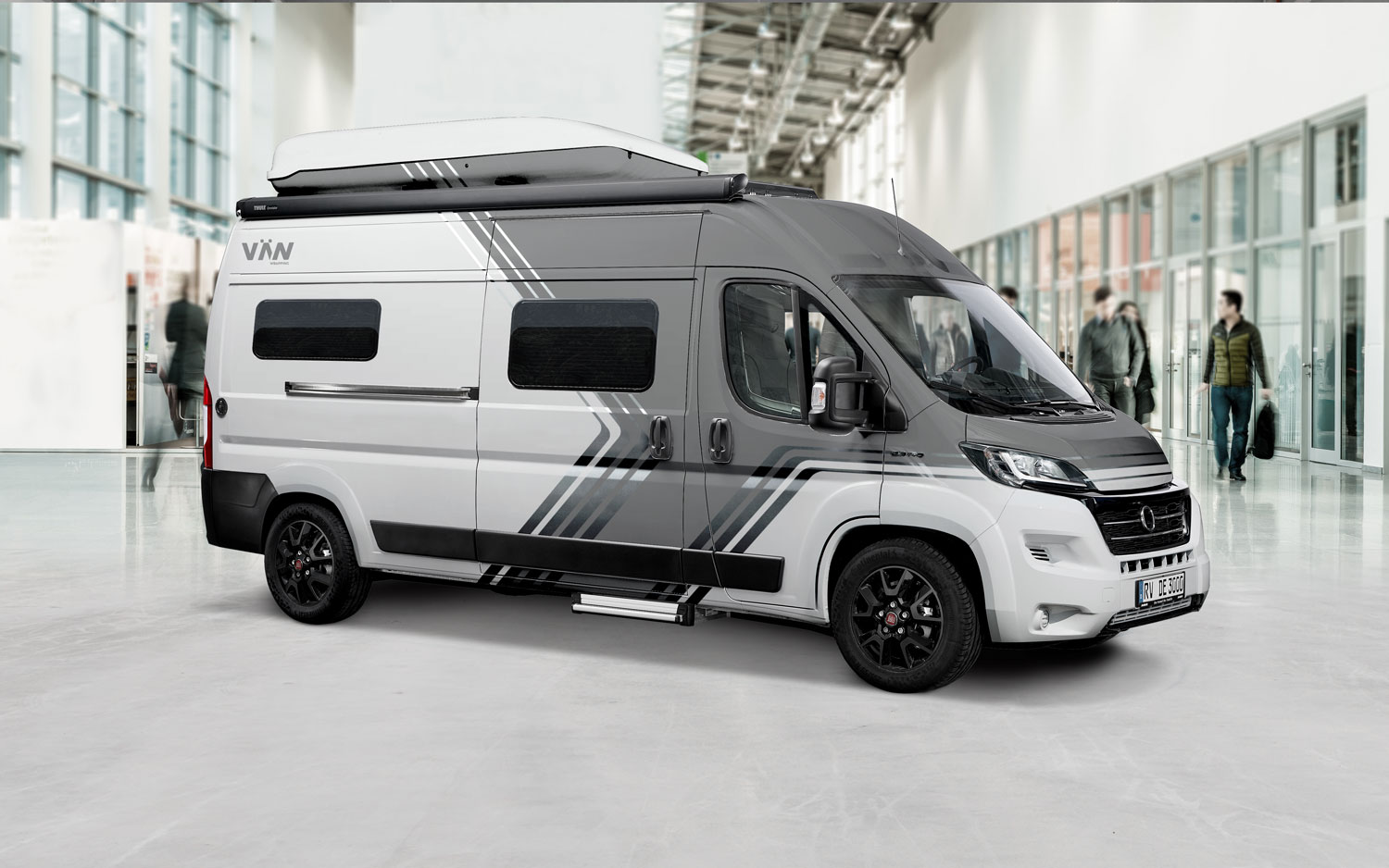 Fiat Ducato Camper – moderne Designfolierung auf der Messe Fiat Ducato Camper mit grauer und schwarzer Designfolierung in einer Messehalle