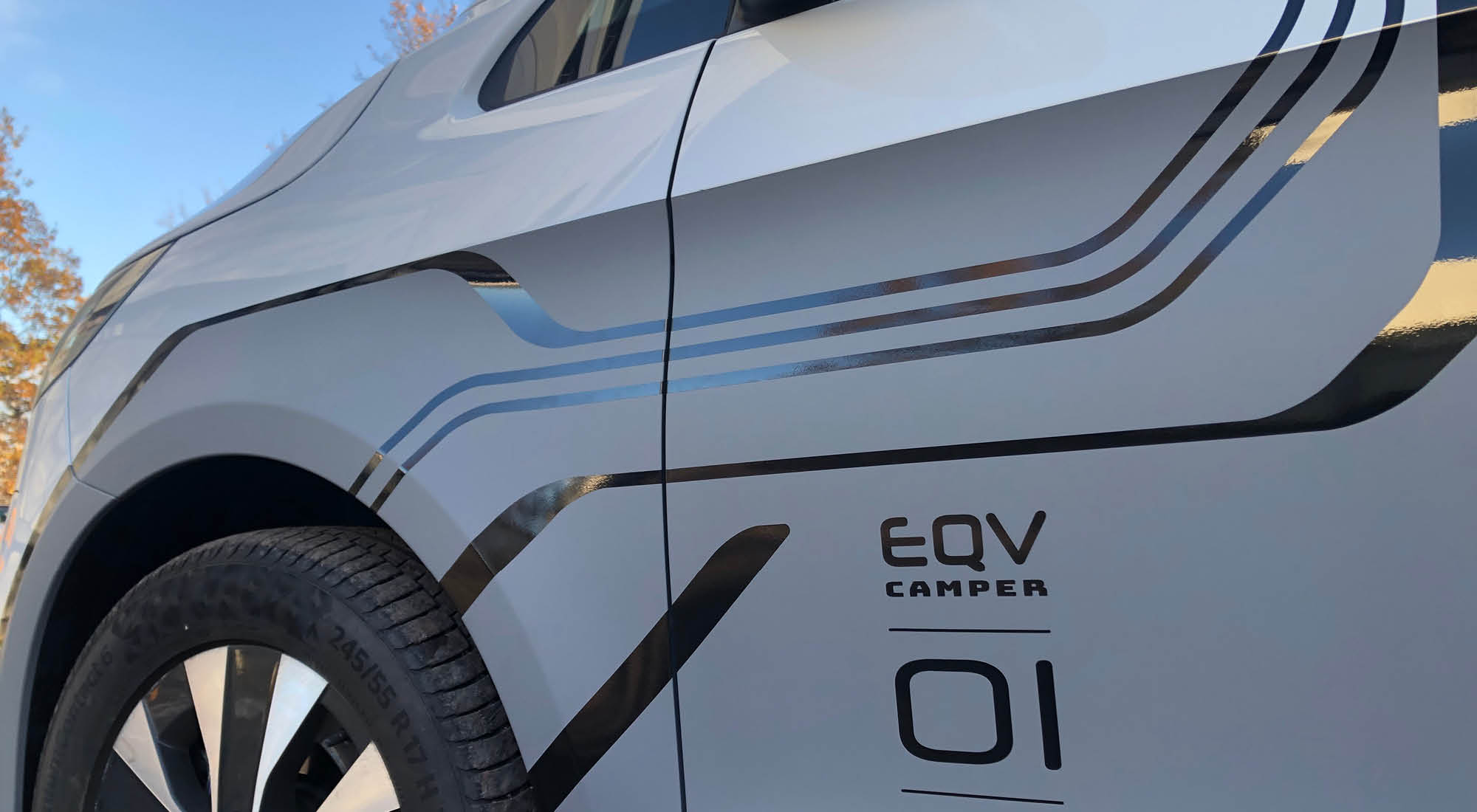 Nahaufnahme der Fahrzeugfolierung am Mercedes EQV Elektrocamper mit Liniengrafik und Schriftzug EQV Camper 01