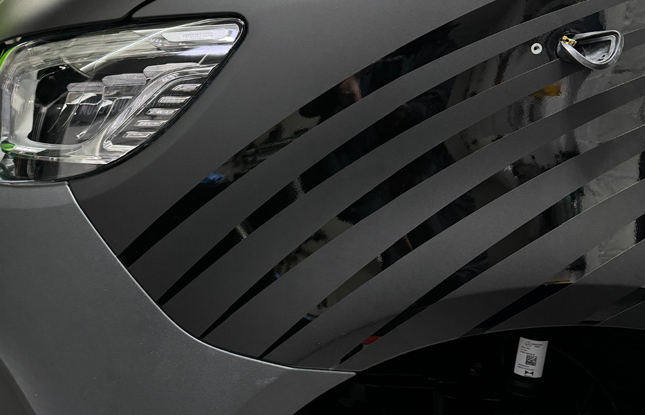 Mercedes Sprinter Folierung mit Wellenreiter-Motiv – seitliche Ansicht am Flügeldes Designs Seitliche Ansicht am Flügel eines Mercedes Sprinter mit Wellenreiter-Motiv als Folierung
