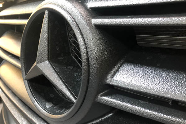 Mercedes Stern Nahaufnahme – hochwertiges Fahrzeugdetail mit Struktur und Glanz Nahaufnahme des Mercedes-Sterns im Kühlergrill – glänzendes Fahrzeugdetail